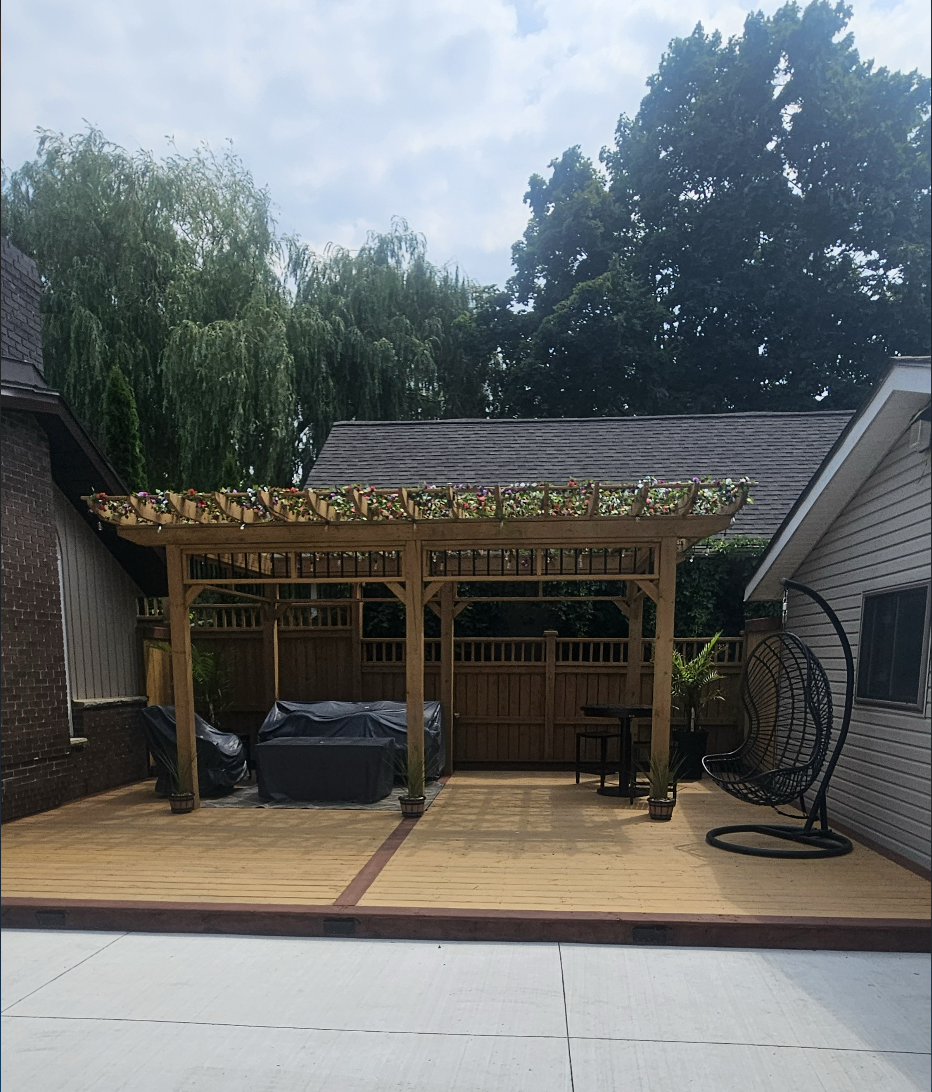 Ground-level deck with a cedar pergola, flower baskets and lounge seating