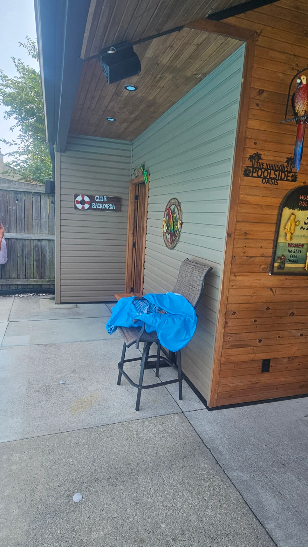 Side entry of a poolside cabana with cedar and vinyl siding and pot lighting