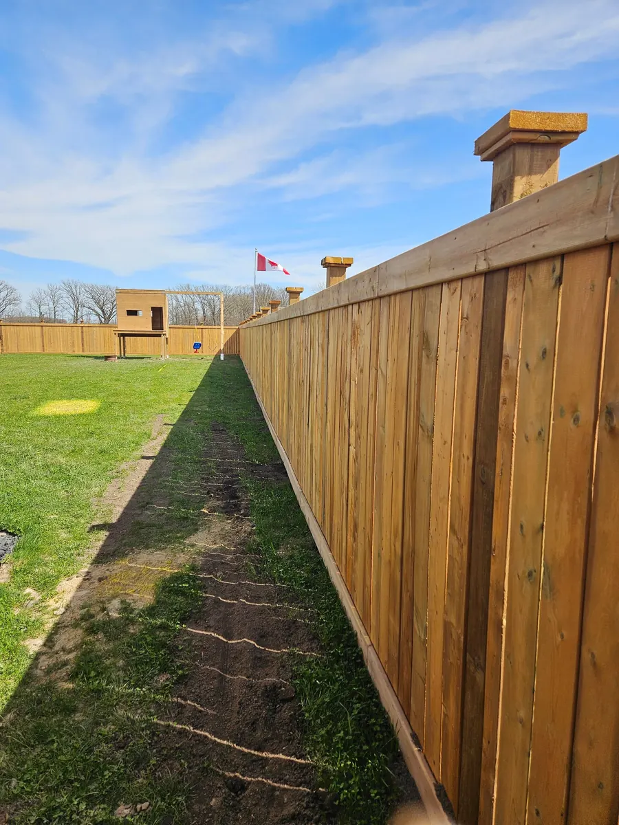 New cedar board privacy fence running the length of a backyard property line