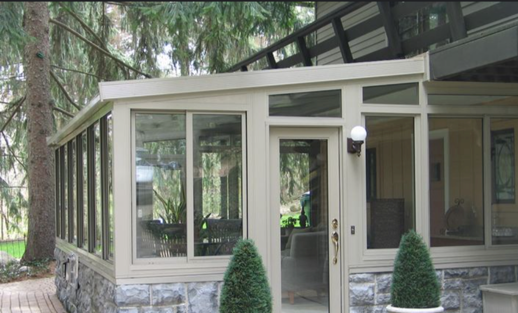 Four-season sunroom addition with glass walls and stone foundation built in Sarnia