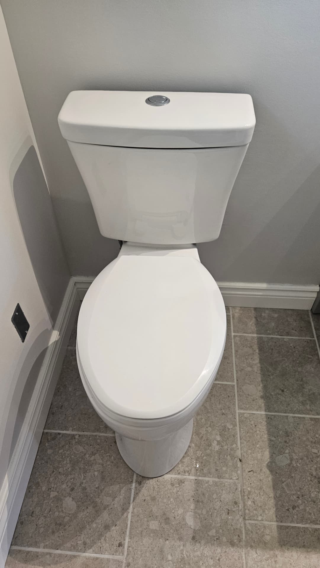 New toilet and tiled floor in a finished bathroom renovation